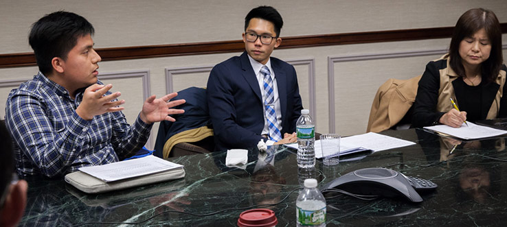 Brooklyn College senior Luiz Cazares explains value drivers and risk of Comcast during an MDSII Meeting in fall 2017.