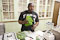 Zenny Felicien holds a bunch of cilantro as he prepares leeli chutney, made from cilantro and peanuts.