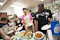 Students fill their plates with the Indian and Bangladeshi dishes they have prepared.