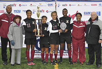 Coach Patrick Horne and Brooklyn College President Karen L. Gould with the new CUNYAC champions. Far right, Athletics Director Bruce Filosa.