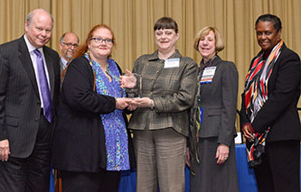 Brooklyn College librarians Jane Cramer (third from left) and Stephanie Walker (third from right) receive their Library of the Year award flanked by officials from the U.S. Government Printing Office. 