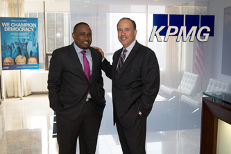 At the KPMG offices in Midtown Manhattan, Anthony Castellanos '84 (right) congratulates Craig Henry '11 on his successful academic and career trajectory.