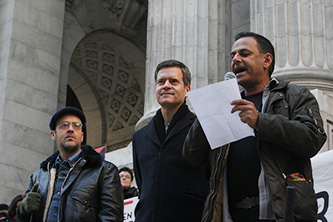 Professor Moustafa Bayoumi reads at the PEN America Writers Resist rally with (from
left) artist-activist Charlie Vásquez and New York State Senator Brad
Hoylman. © Terrence Jennings