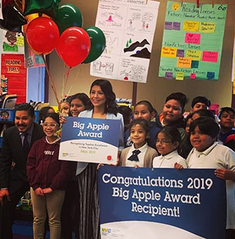 Yadira Hans '11, '17 M.S. with students celebrating her Big Apple Award for Excellence in Teaching