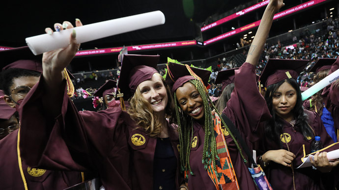 Some of the newest Brooklyn College graduates celebrate as the confetti falls at Barclays Center at the close of the 97th commencement ceremony May 31.