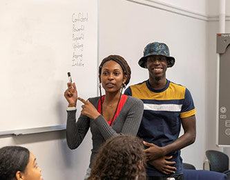 Summer Enrichment Academy students Brittany Wilson and Salif Soumahoro listing CUNY EDGE leadership qualities that SEA members suggested during the closing ceremony.