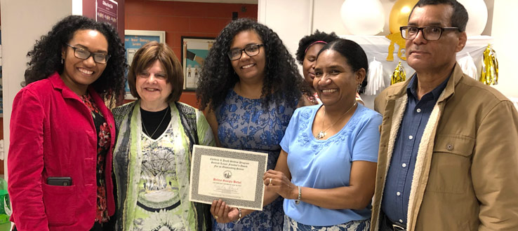 CHST instructor Irma Kramer presents Belicia Bethel (pictured with her family) the Gertrud Lenzer Founder’s Outstanding Senior Award 