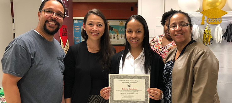 CHST faculty Dr. Erika Niwa presents Tatyana Candelaria (pictured with her family) the Certificate of Recognition Senior Award 