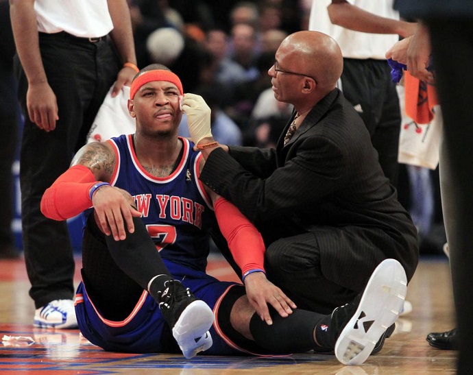 NY Knicks Head Athletic Trainer Roger Hinds '77 tends to injured small forward Carmelo Anthony during a game.