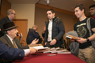 Andrew Burian, author of <em>A Boy from Bustina: A Son. A Survivor. A Witness. </em>autographs his memoir.<br />
<em></em>