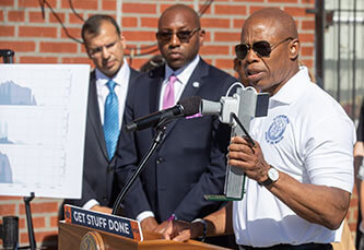 Mayor Eric Adams holds up a FloodNet sensor at his press conference on September 1 in Queens.